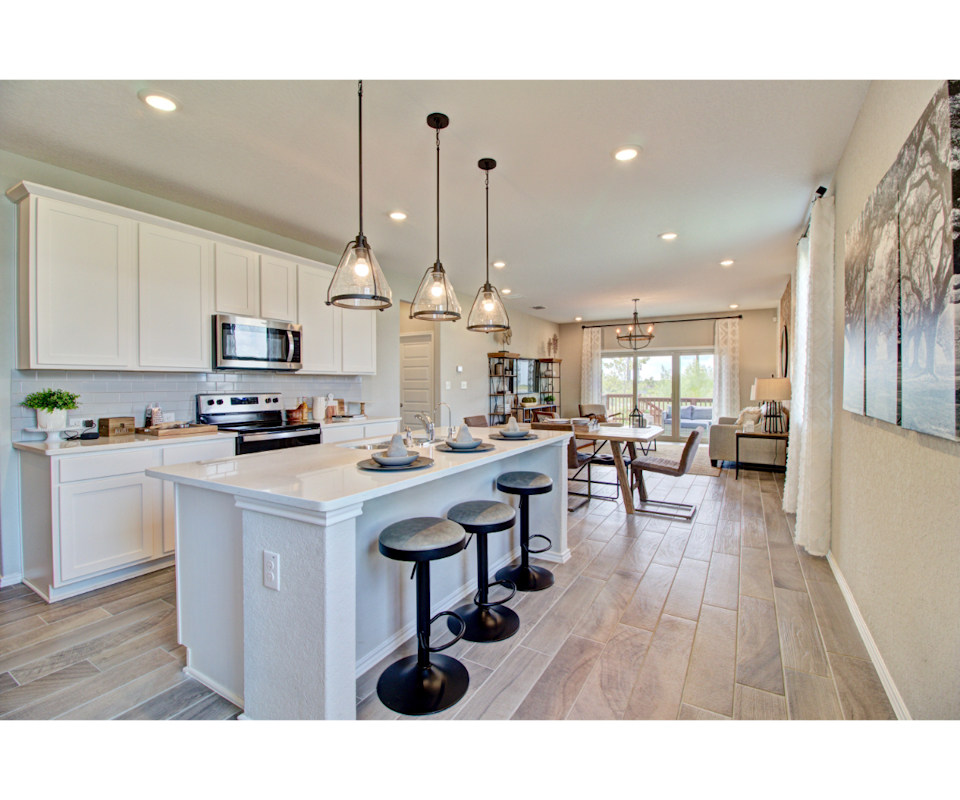 A kitchen with a bar stool and a table.