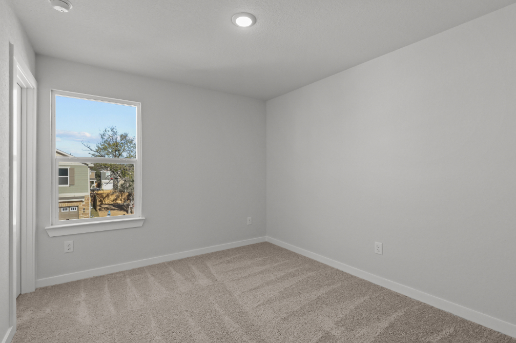 A room with a window and a carpet.