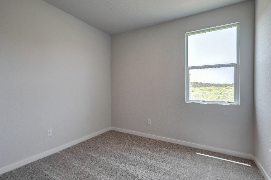 A room with a window and a carpet.
