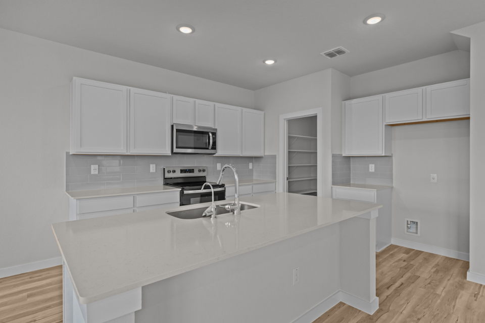A kitchen with white cabinets.