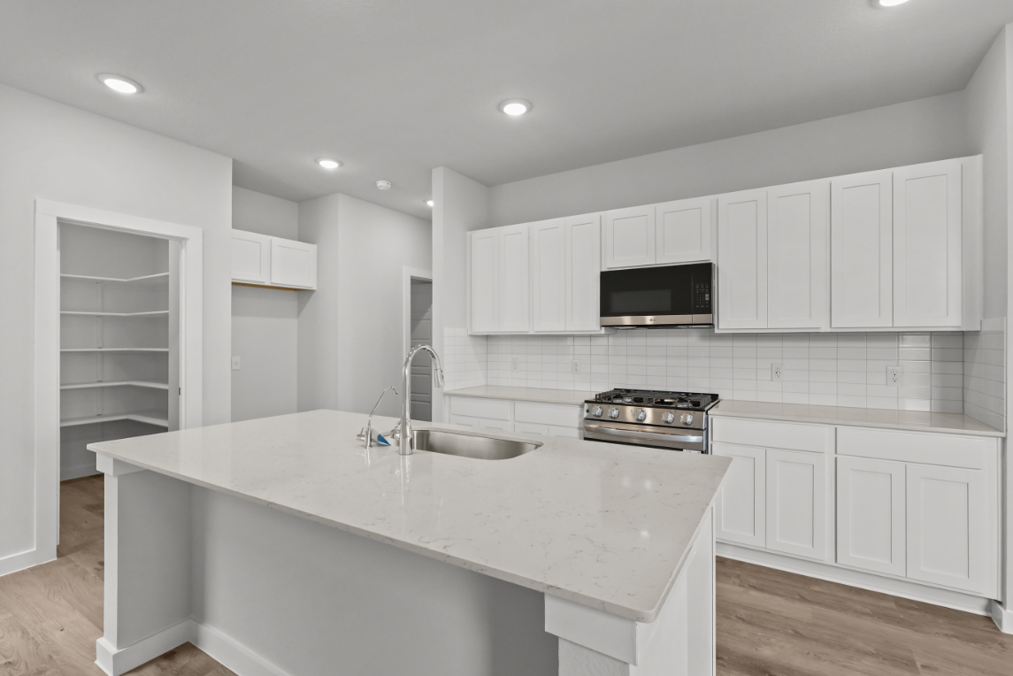 A kitchen with white cabinets.