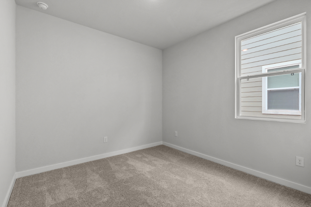 A room with a window and a carpet.