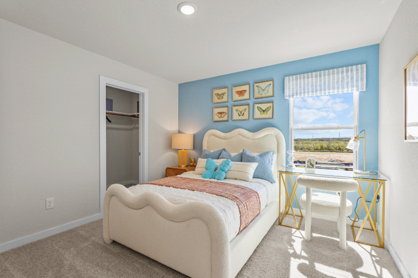 A bedroom with a bed and a table.