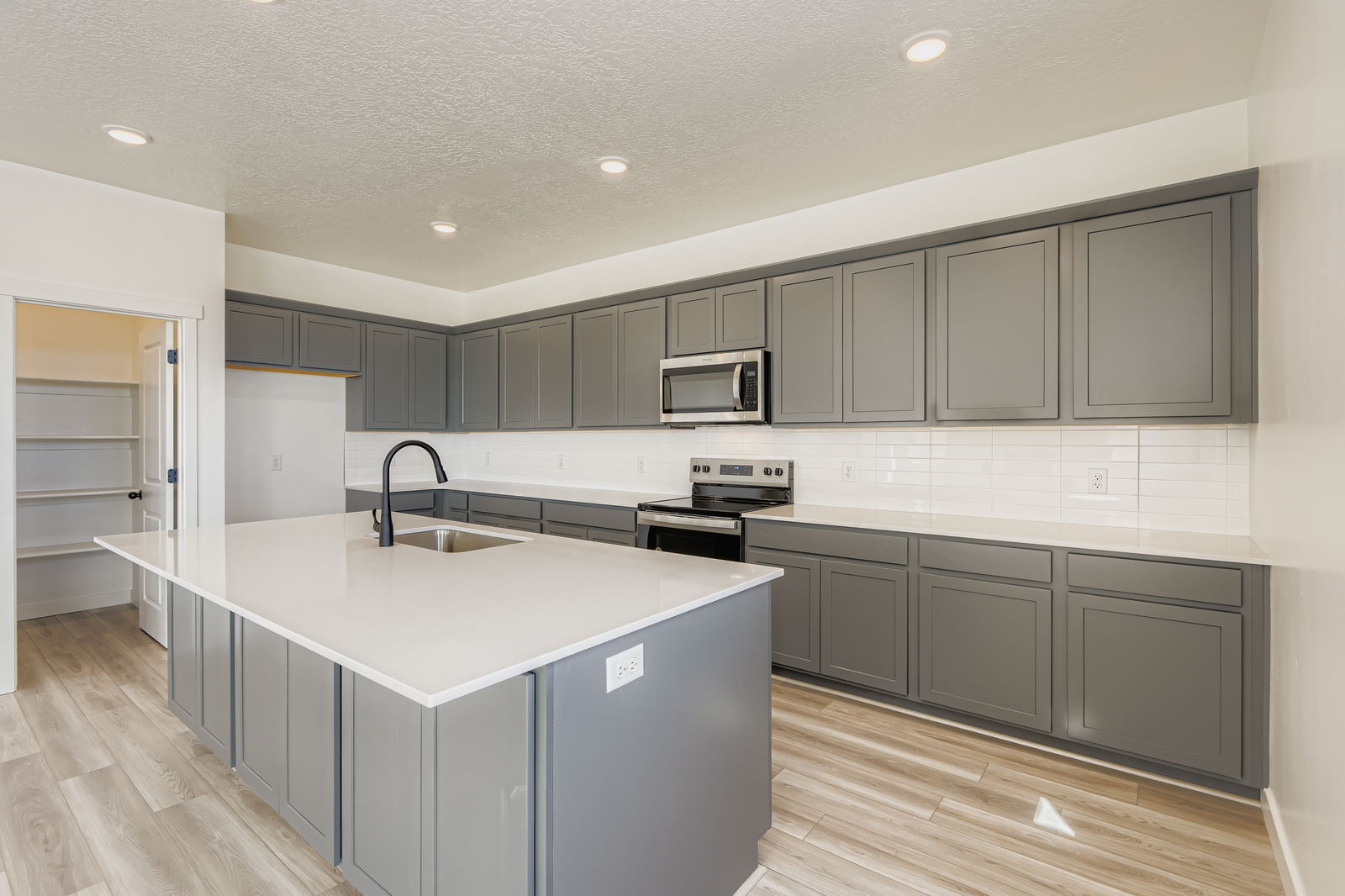 A kitchen with white cabinets.