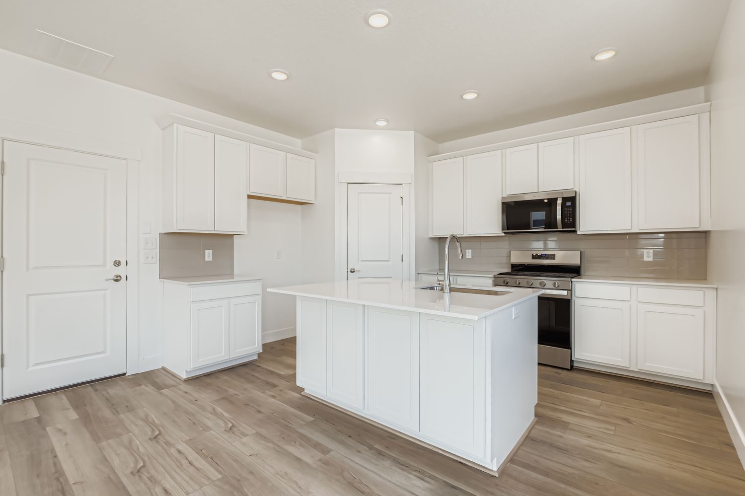 A kitchen with white cabinets.