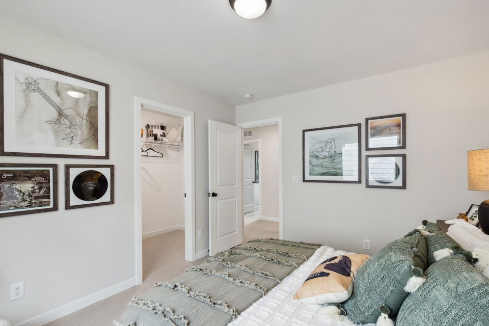 A bedroom with a bed and a lamp.