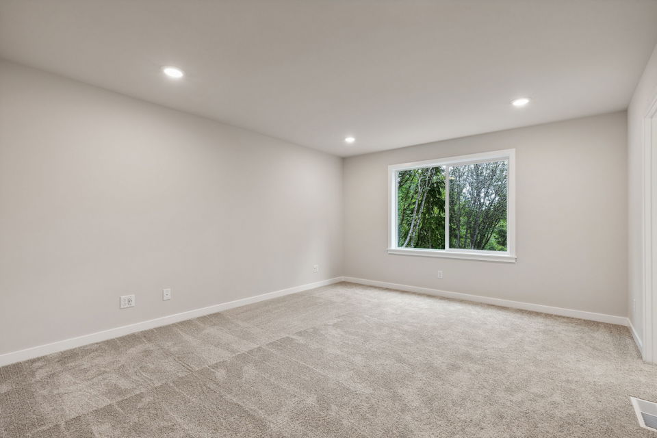 A room with a window and a rug.