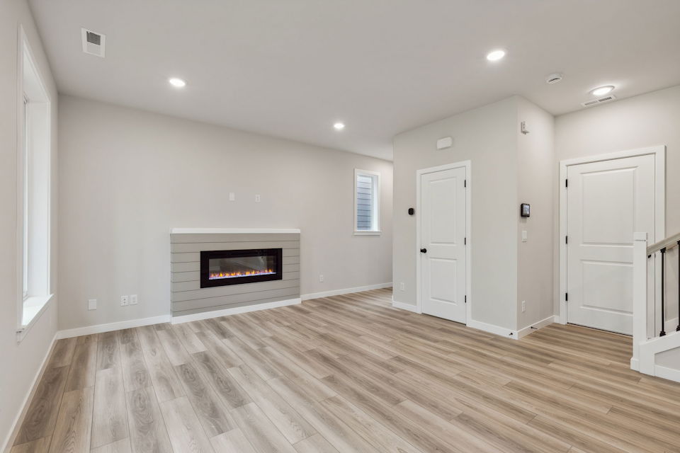 A room with a fireplace and wood floors.