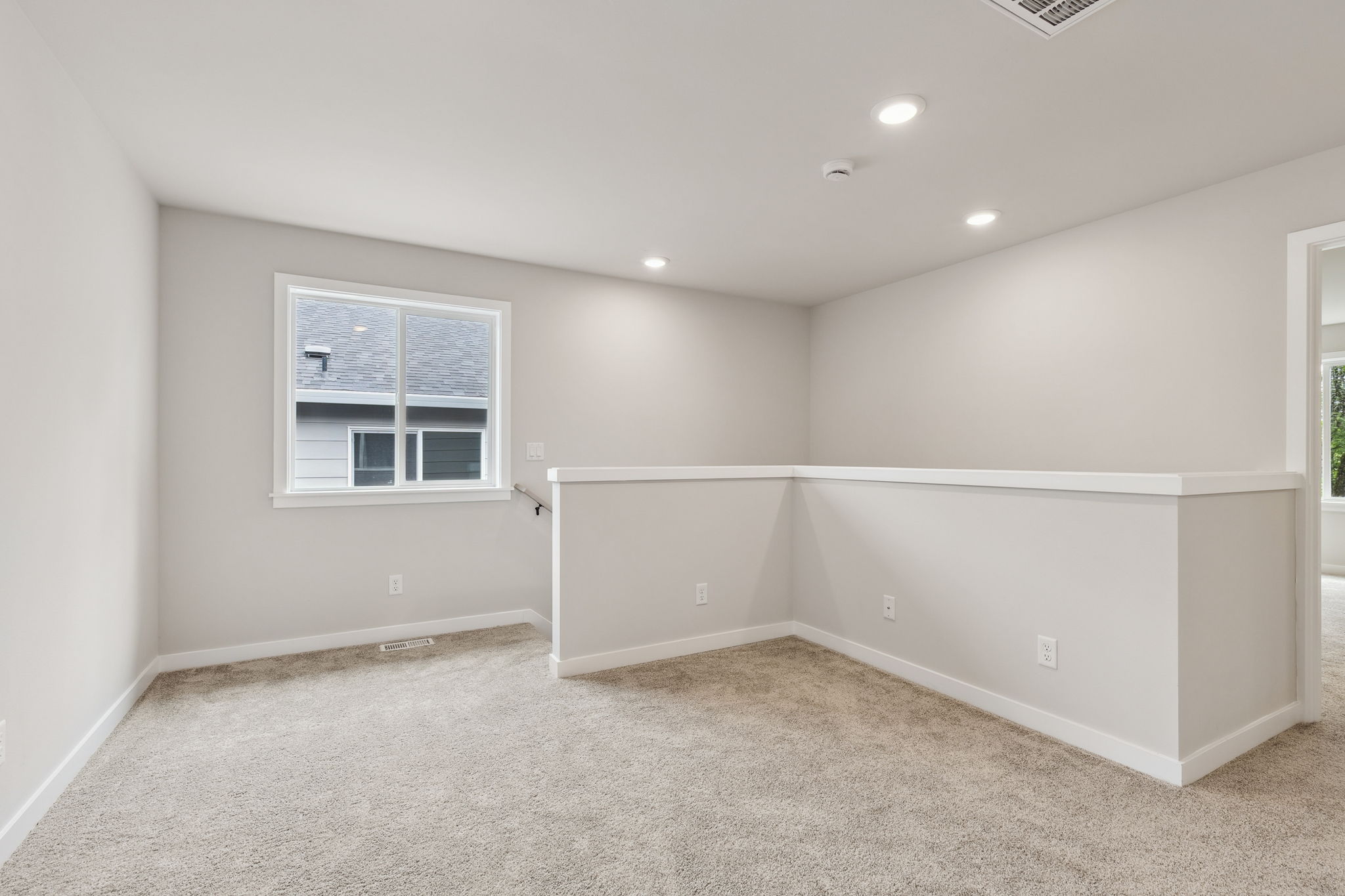 A room with a window and a carpet.