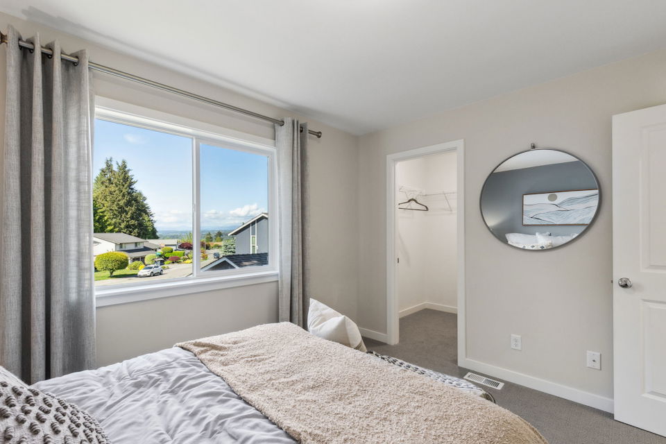 A bedroom with a large window.
