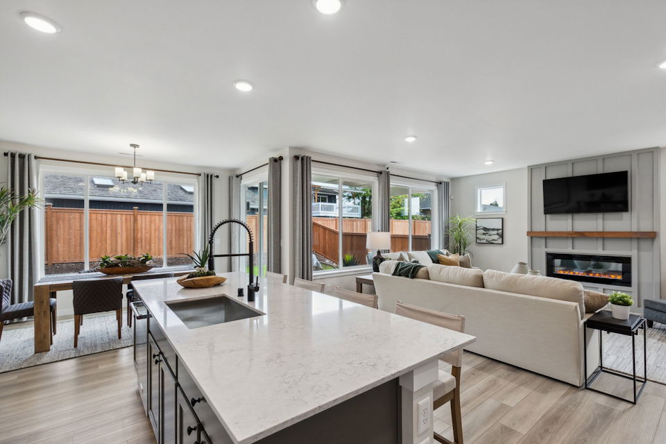 A large living room with a large white table and a large window.