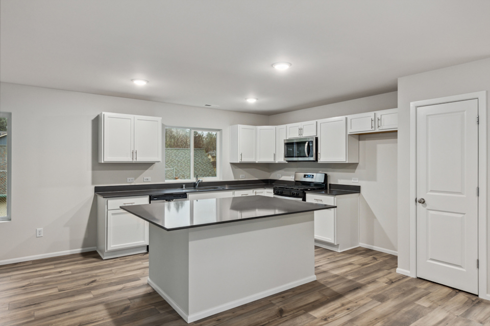 A kitchen with white cabinets.