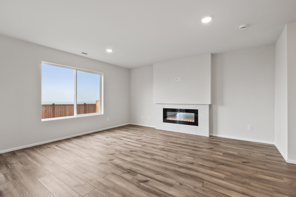 A room with a fireplace and a wood floor.