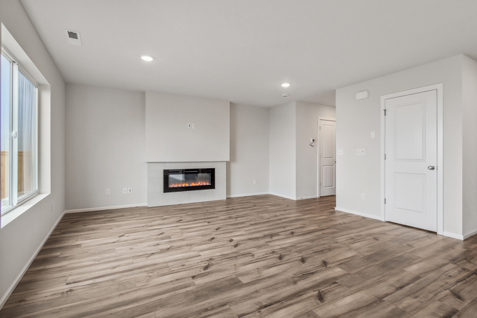 A room with a fireplace and wood floors.