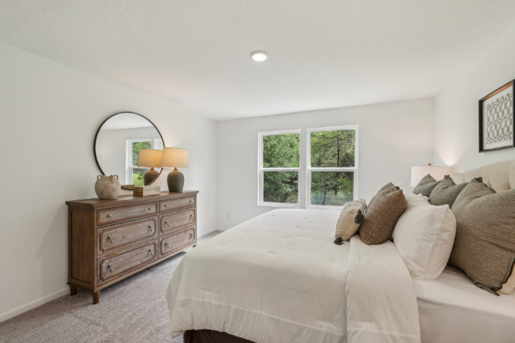 A bedroom with a bed and a dresser.