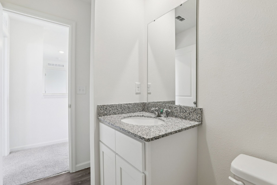 A bathroom with a sink and a mirror.