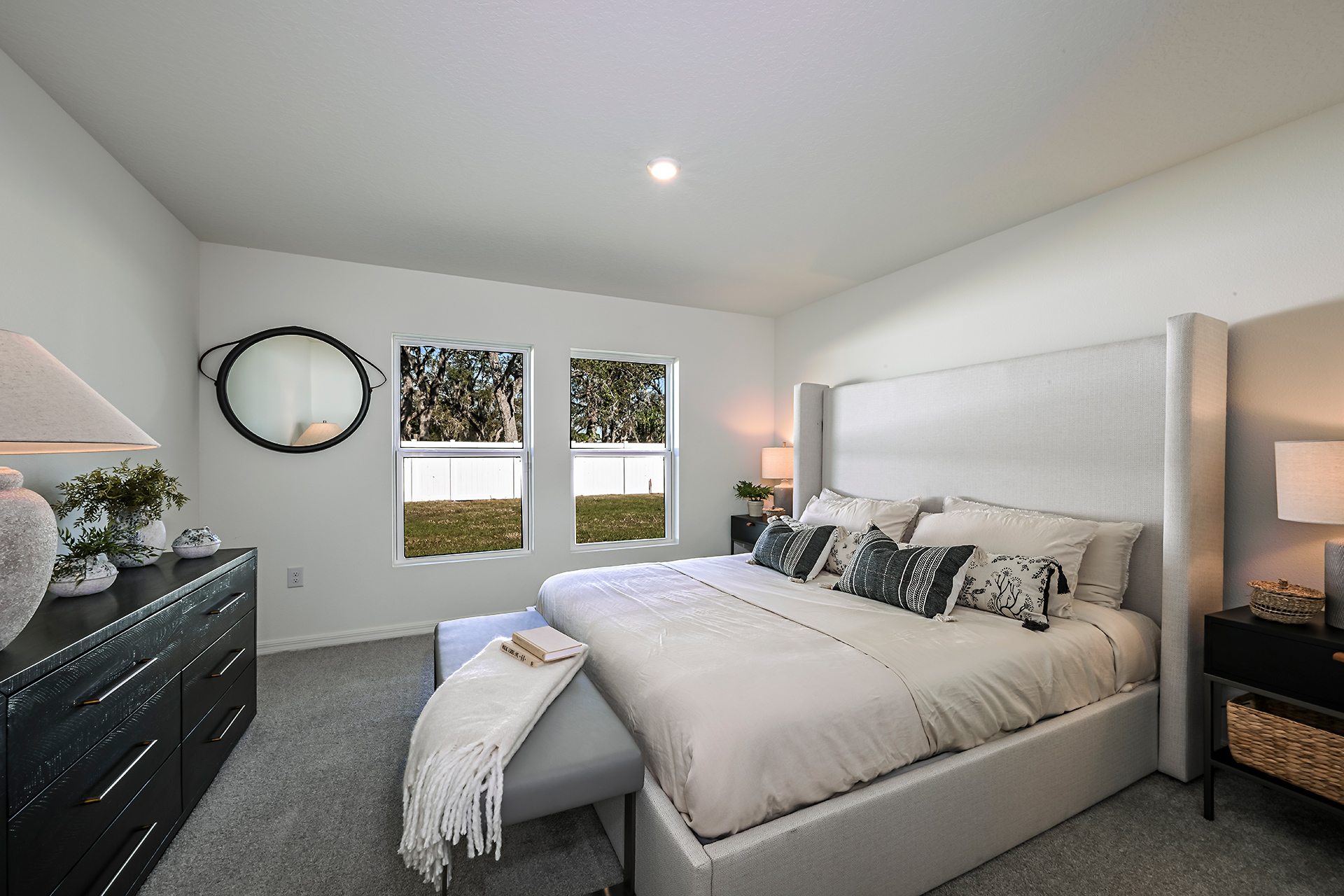 A bedroom with a bed and a mirror.