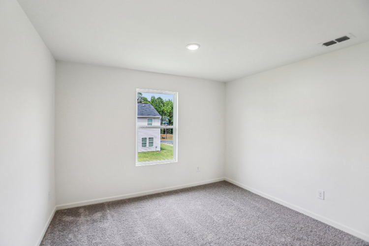A room with a window and a carpet.