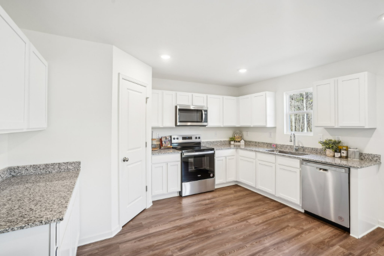 A kitchen with white cabinets.