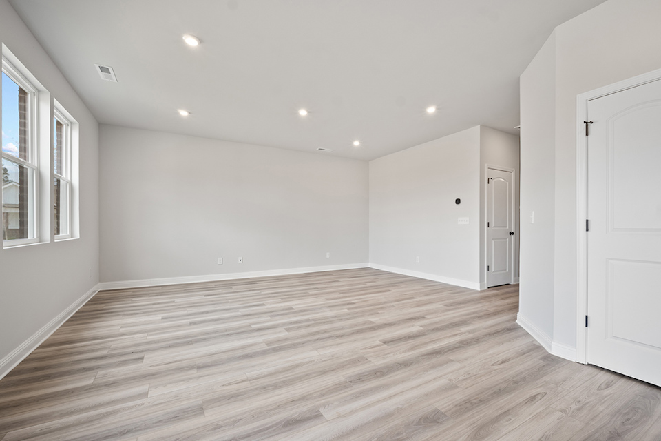 A room with white walls and wood floors.
