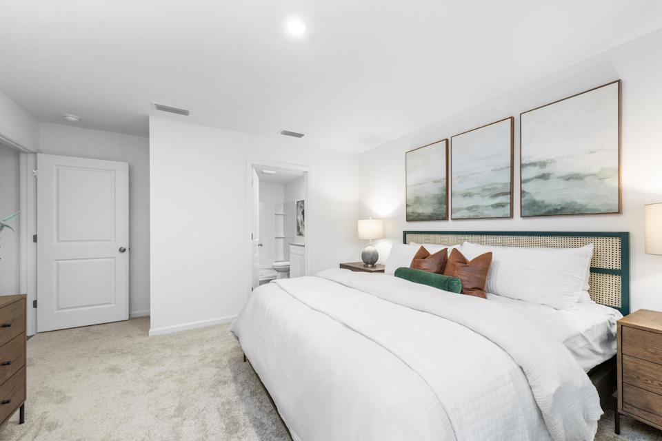 A bedroom with a bed and a lamp.