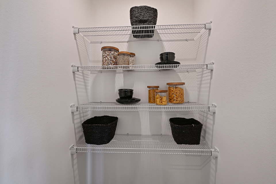 A white shelving unit with various objects on it.