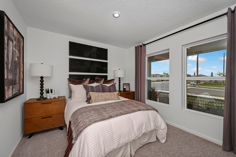 A bedroom with a large window.