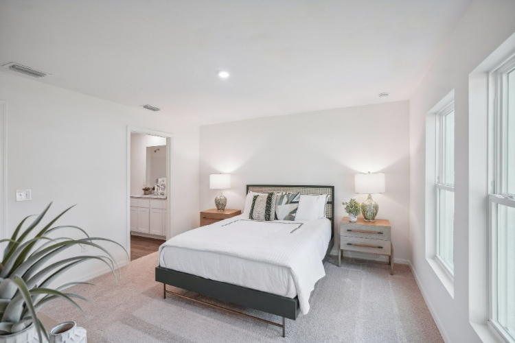 A bedroom with a bed and lamps.