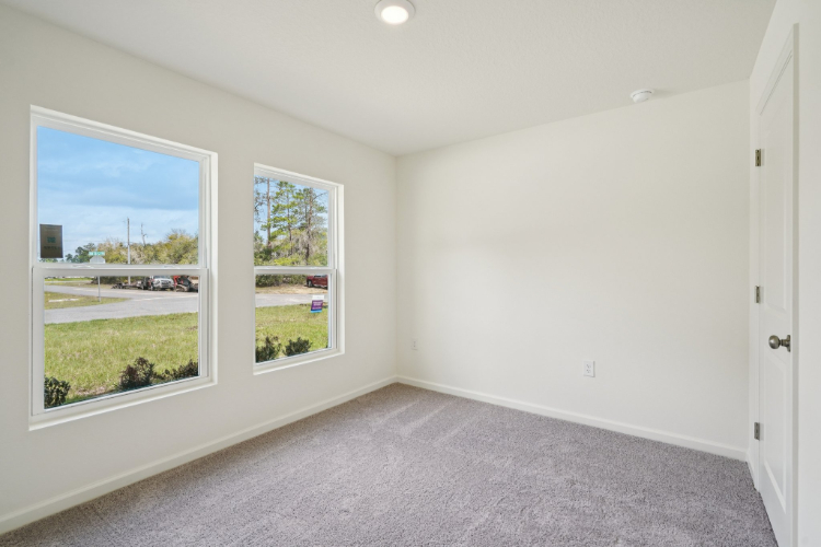 A room with a window and a carpet.