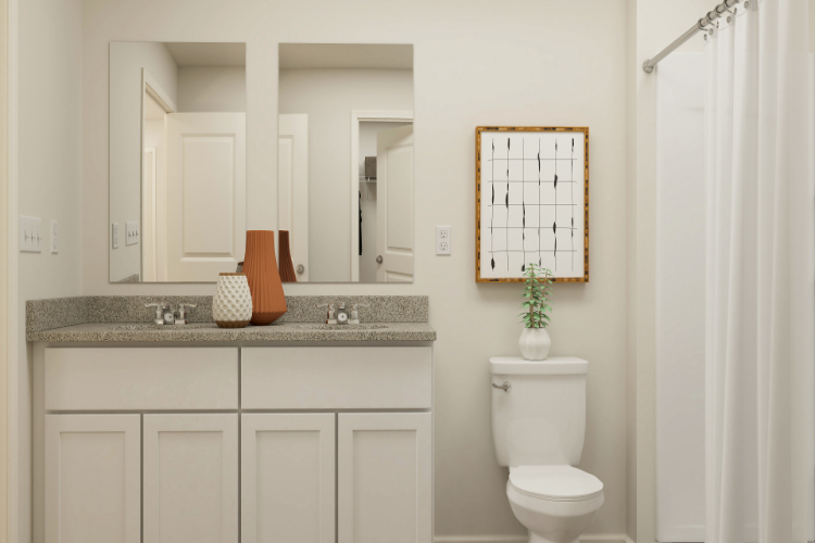 A bathroom with a sink toilet and mirror.