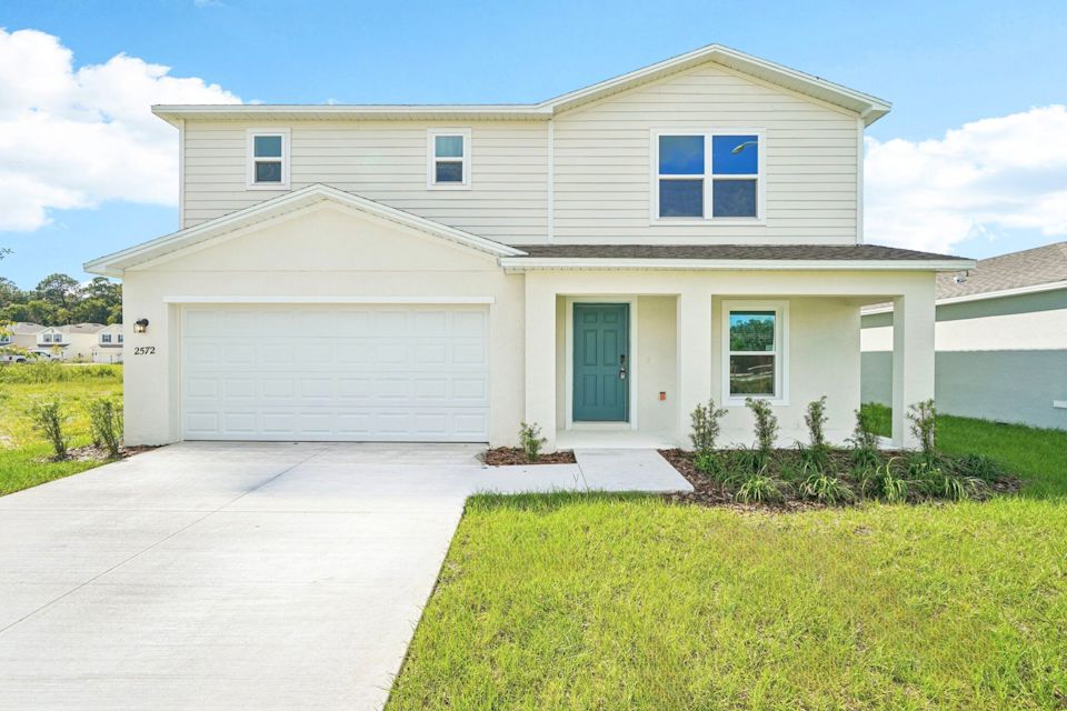A white house with a garage.