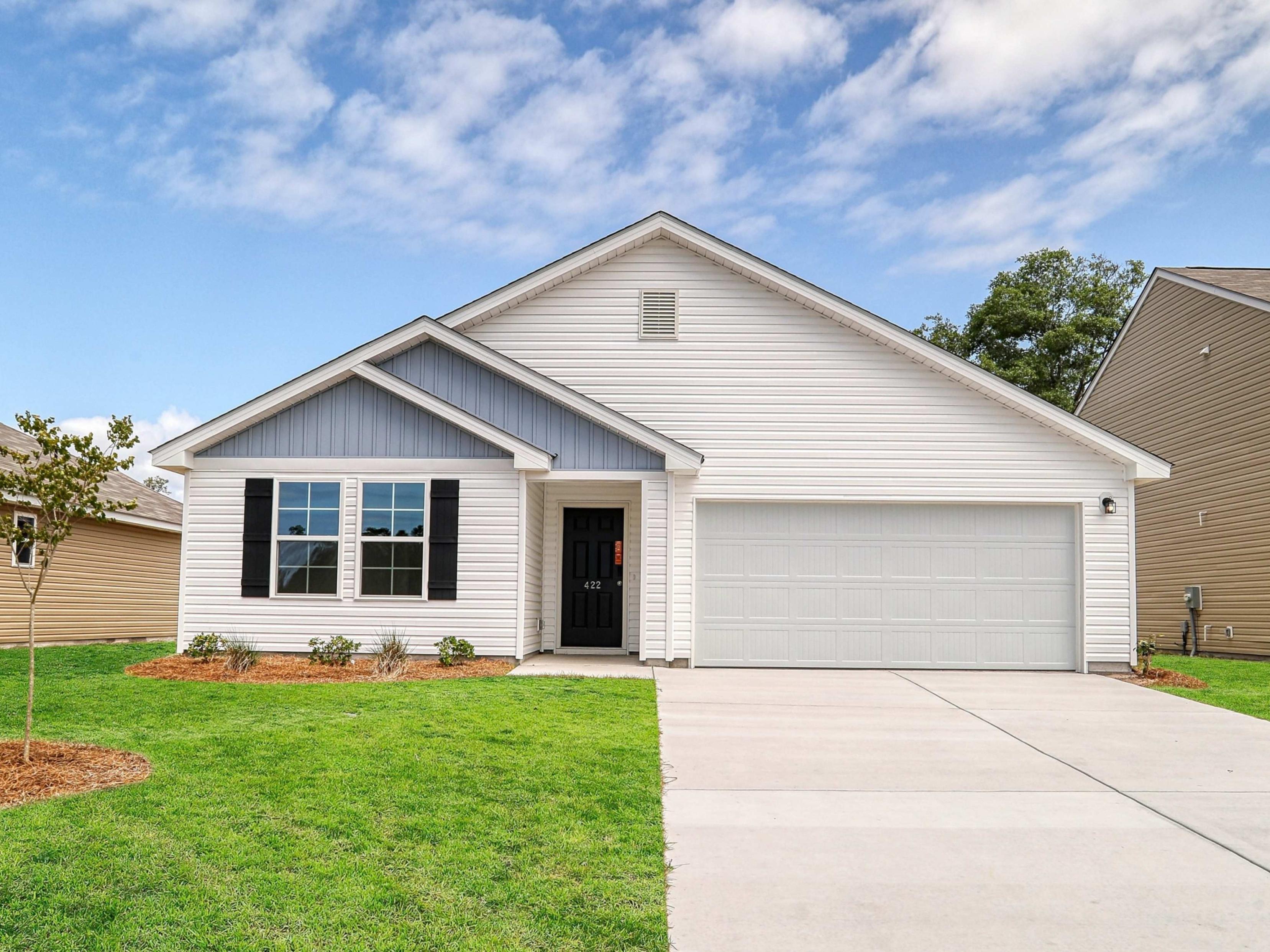 A white house with a green lawn.